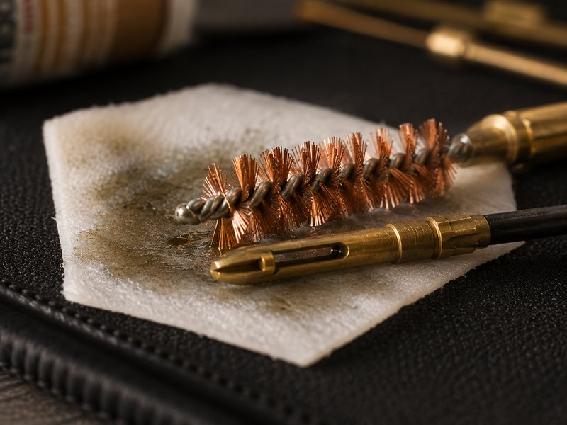 Macro close-up of a brass bore brush and jag tip on a cleaning patch