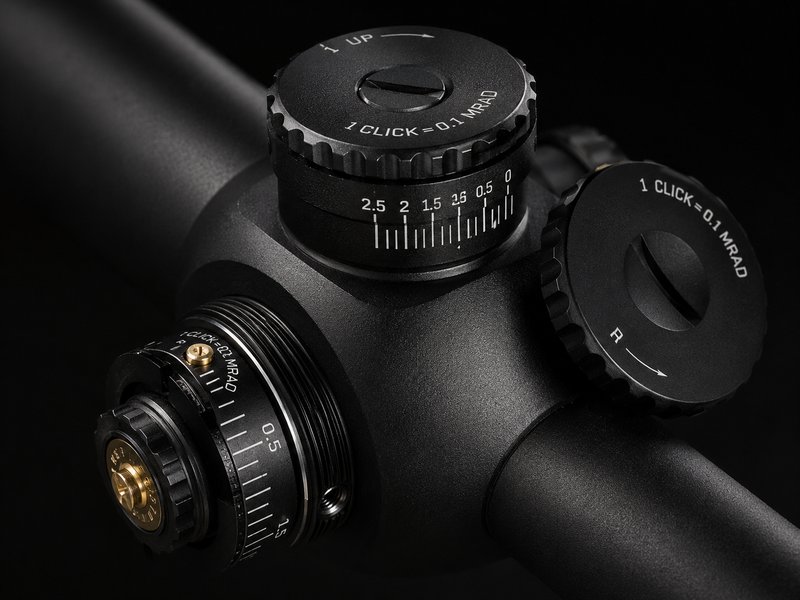 Close-up of precision scope turrets showing MRAD click adjustments